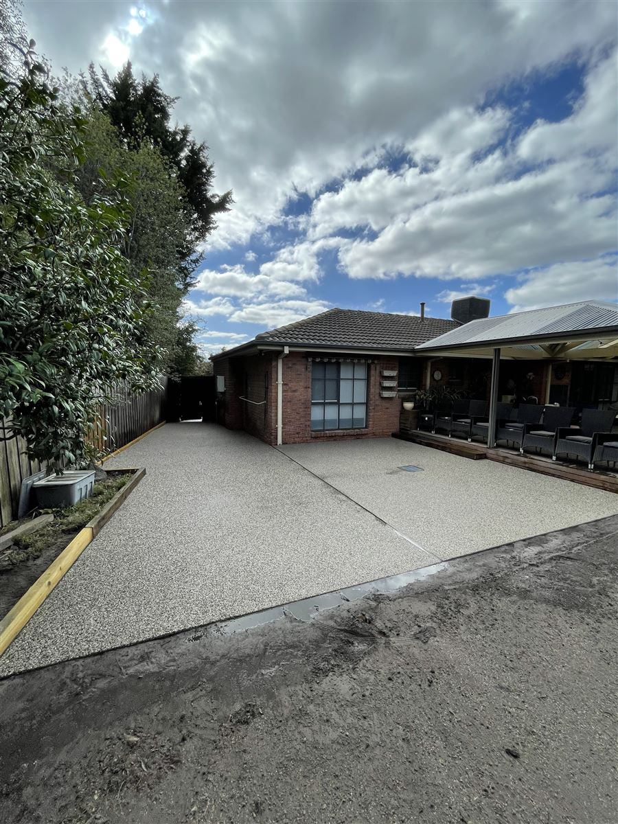 Exposed aggregate concrete pathway alongside a home, built by Sunnybank Horticultural